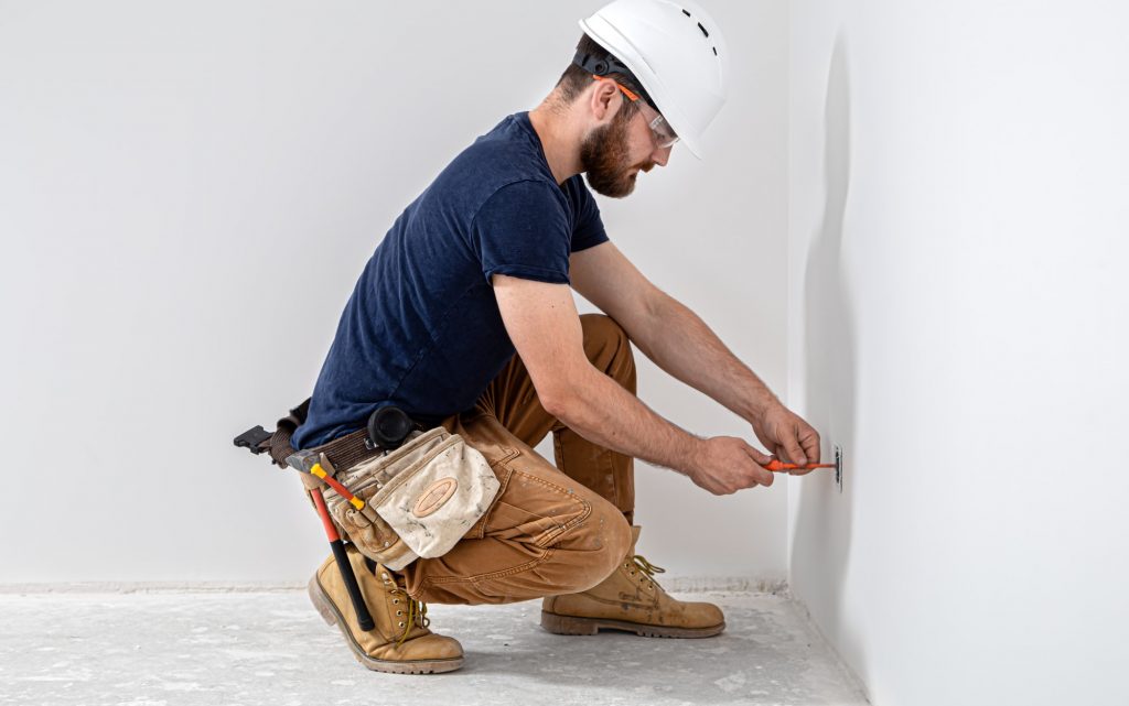 Electrician Builder at work, installation of sockets and switches.